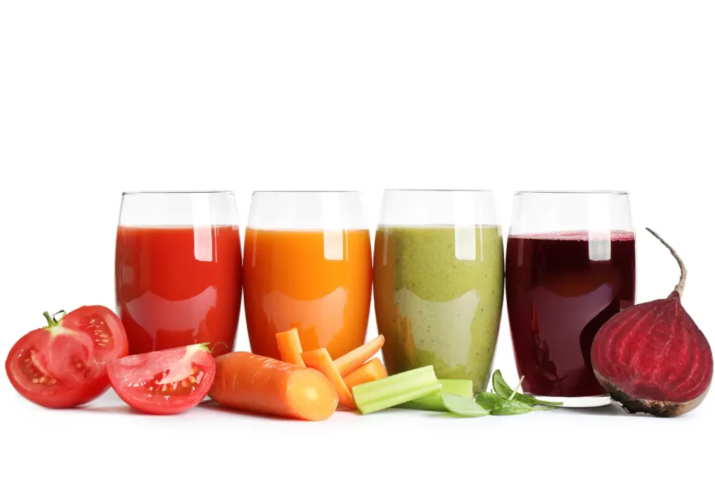 Different types of vegetable juice in glasses: beet, carrot, celery, and tomato juice.