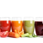 Different types of vegetable juice: glasses of beet, carrot, celery, and tomato juice.