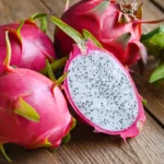 Three whole dragon fruit and one cut in half showing its flesh.