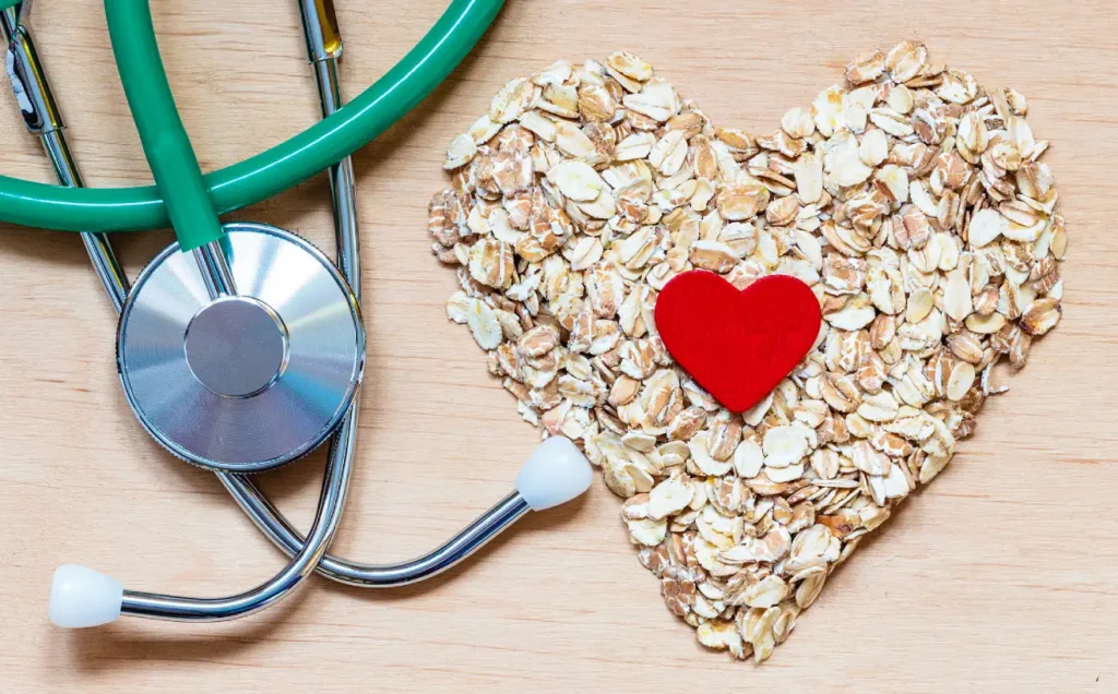 Oats arranged in a heart shape next to a stethoscope.