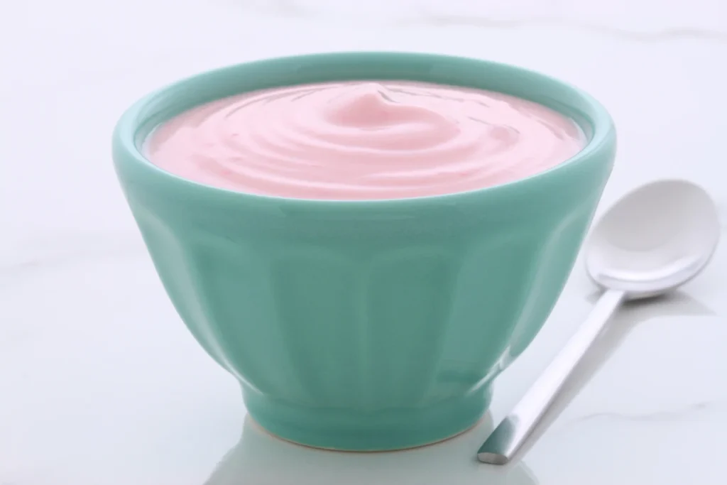 A serving of protein yogurt in a green bowl.