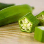 Fresh chopped okra on a wooden surface.