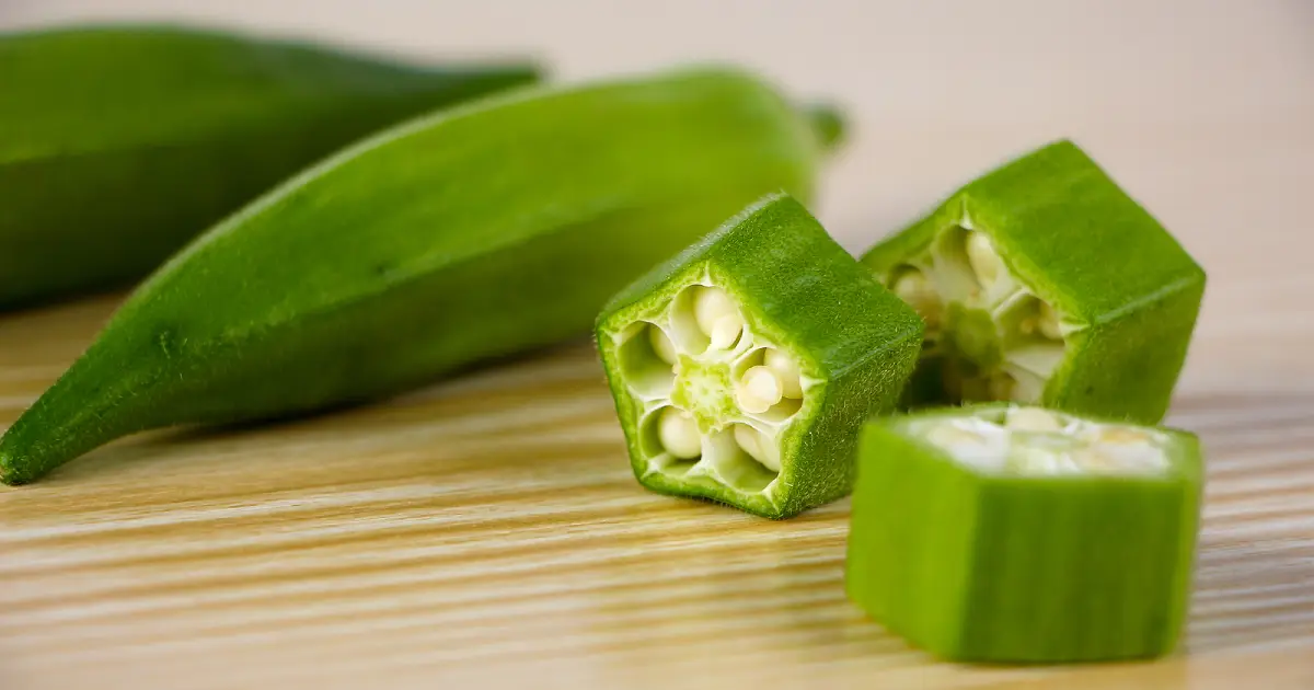 Fresh chopped okra on a wooden surface.