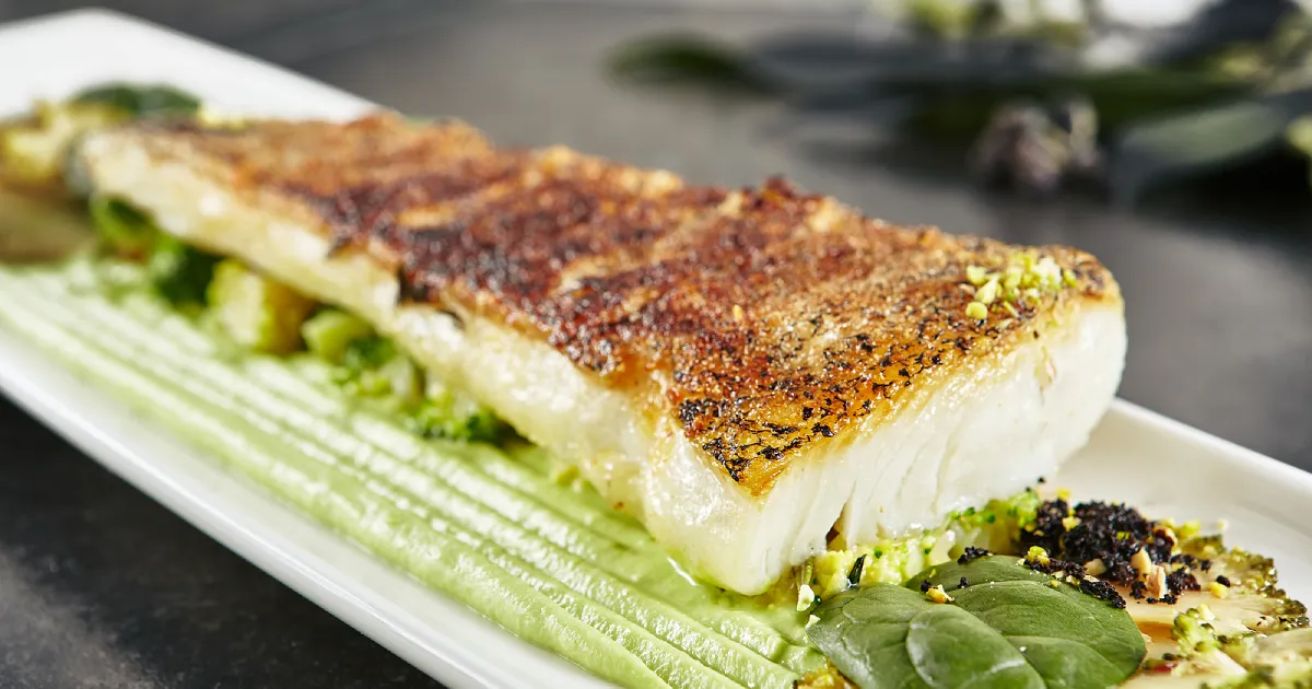 A Baked fillet of halibut on a plate.
