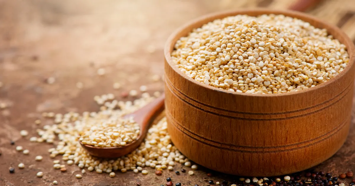 A wooden bowl of quinoa grains.