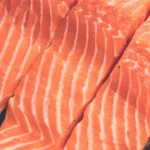 5 Key Benefits of Salmon (and Full Nutrition Profile) Three raw farmed Atlantic salmon fillets.