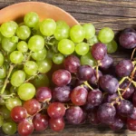 Grapes: Nutrition Facts & Potential Health Benefits Bunches of green and red grapes on a wooden surface.